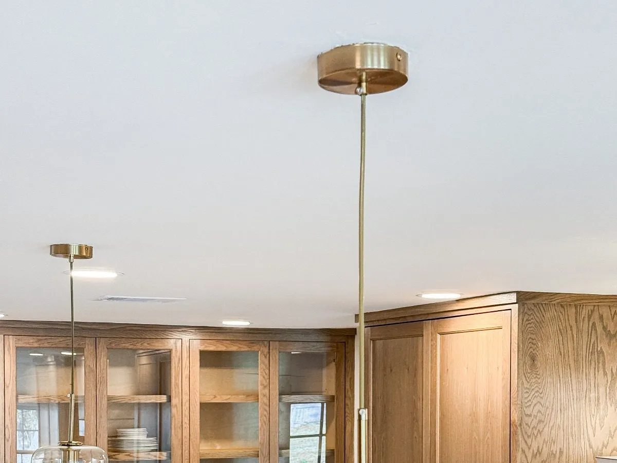 Unlacquered brass pendant lighting above a kitchen island in The Woodlands, TX