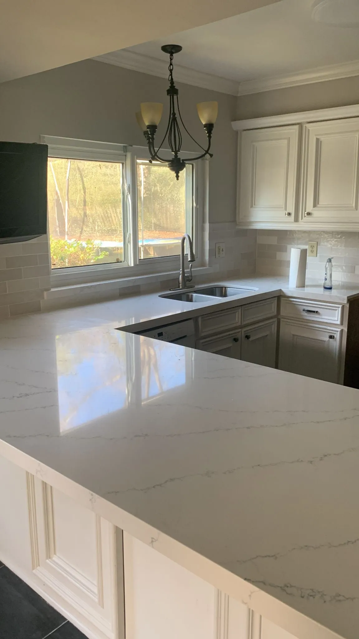 Ivory raised-panel kitchen with quartz counters and a stone backsplash in Cochran’s Crossing, The Woodlands, TX