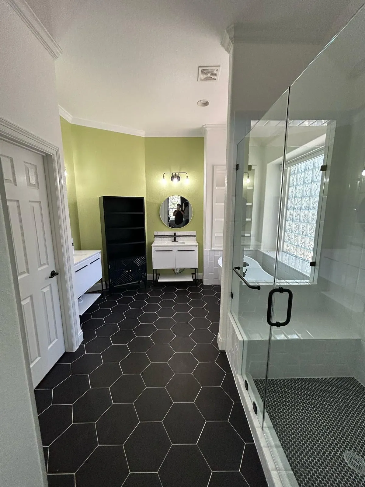 Bathroom remodel with a freestanding tub, black hexagon floor tile, and a floating vanity in The Woodlands, TX