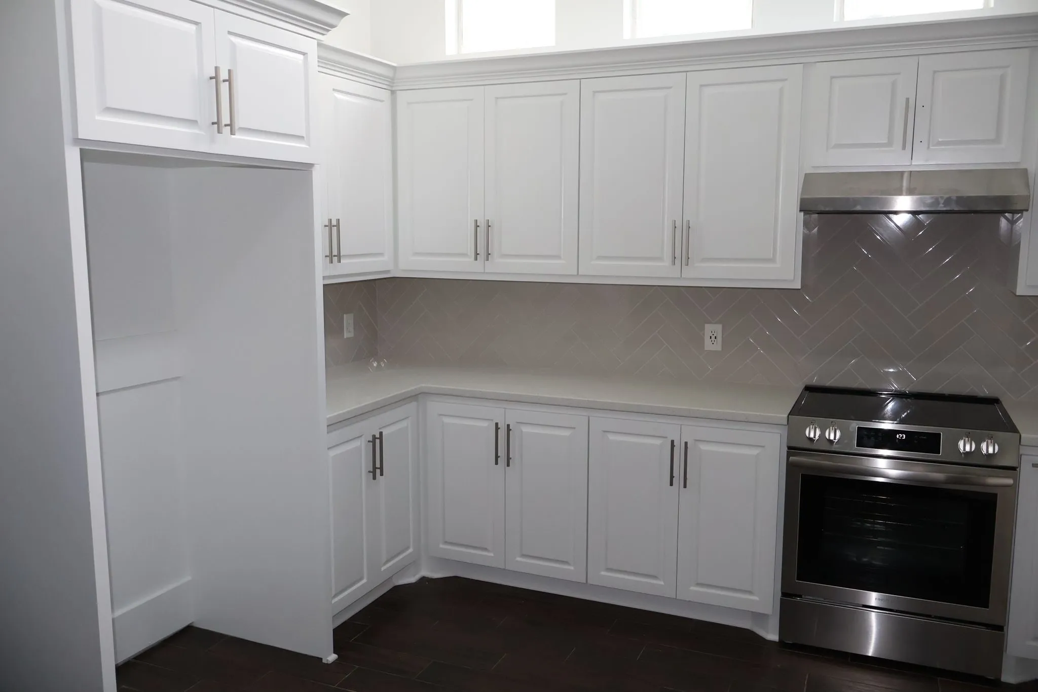 White shaker kitchen remodel with a herringbone backsplash in Panther Creek, The Woodlands, TX