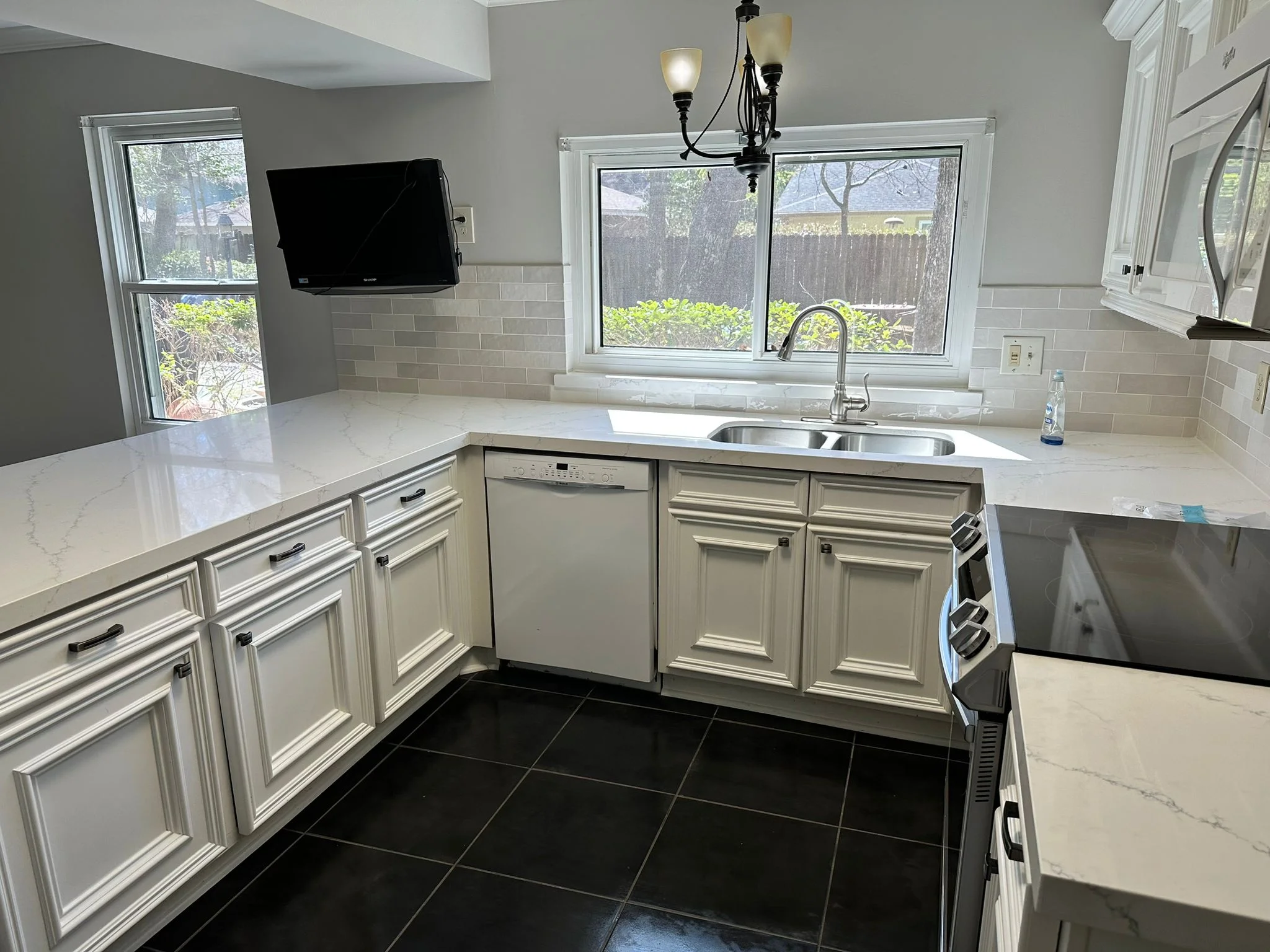 Quartz countertops with tile backsplash in a kitchen remodel in The Woodlands, TX