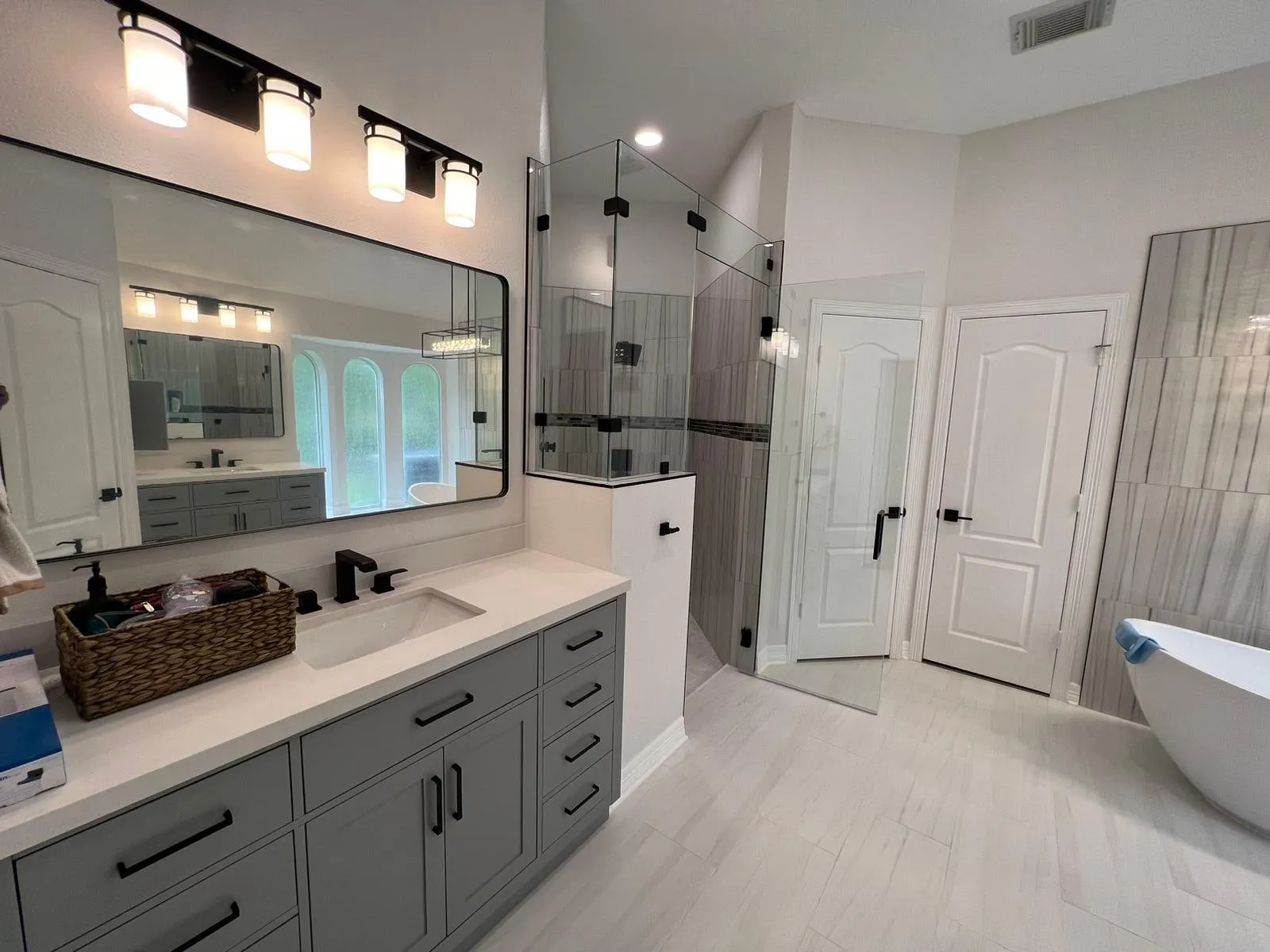 Primary bathroom suite with a freestanding tub and a curbless stone wet room in Sterling Ridge, The Woodlands, TX